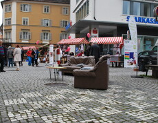 carla stellt wieder Instandgesetzte Möbel in der feldkircher Innenstadt aus. Zwei Roll-ups und eine schwarze Couch stehen am Sparkassenplatz. 
