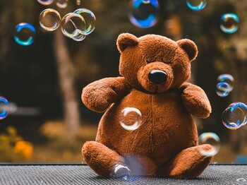 Teddybär sitzt in Seifenblasen