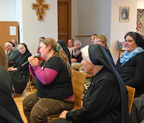 Viele Menschen, auch Nonnen in einem Saal
