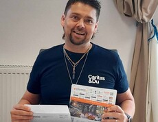 Mann kuvertiert Kalenderblatt in Briefumschlag ein