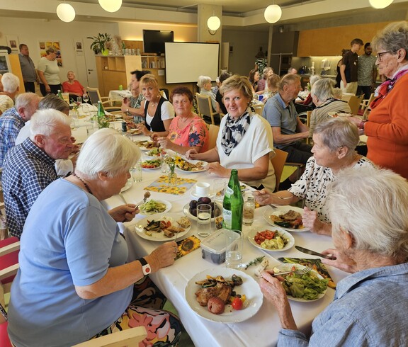 Beim Sommerfest im Pflegewohnhaus genießen zahlreiche Bewohnerinnen und Bewohner gemeinsam ein festliches Mittagessen an liebevoll gedeckten Tischen und verbringen gesellige Stunden in angenehmer Gemeinschaft.