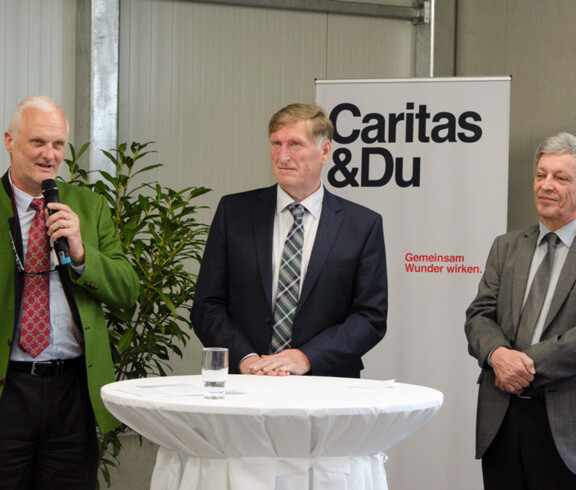 Drei Männer begrüßen zur Eröffnung 