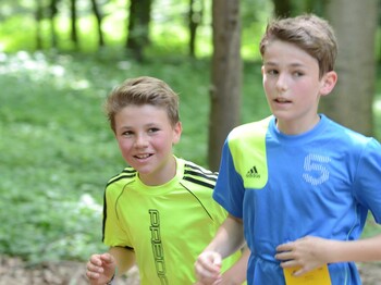 Zwei Burschen laufen im Wald