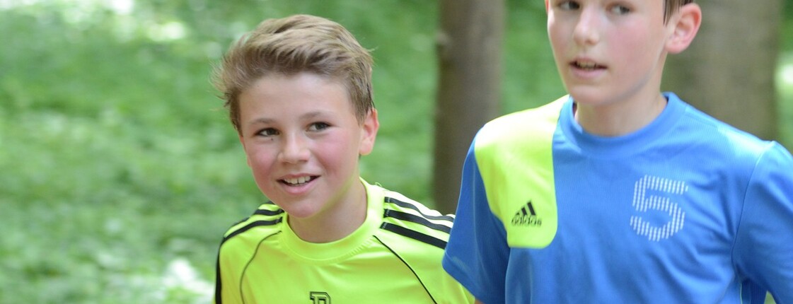 Zwei Burschen laufen im Wald