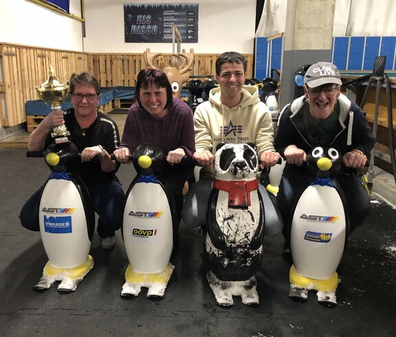 Vier Personen mit Eislauf-Pinguinen