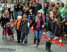 Kinder in gewöhnlicher Straßenkleidung - warm angezogen -  gehen durch die feldkircher Innenstadt um ihre modische Kleidung zu präsentieren. 