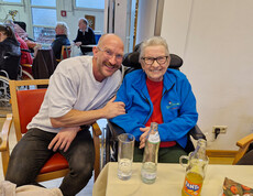 Zwei Personen sitzen eng beisammen am Tisch, Getränke und Weihnachtsdeko sichtbar