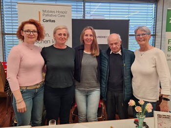 Fünf Frauen und ein älterer Herr stehen nebeneinander und schauen frontal in die Kamera