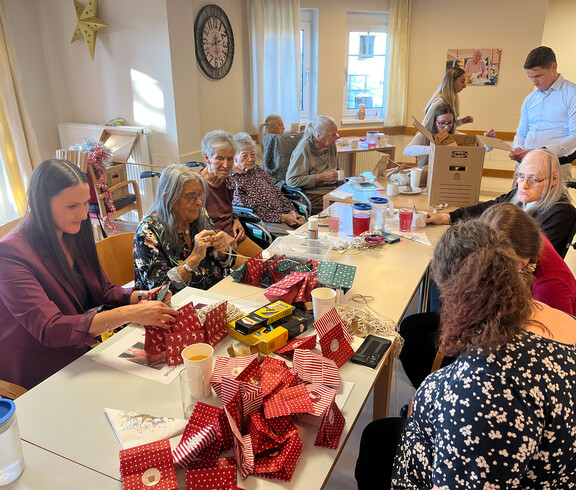 Gruppe gestaltet Adventkalender mit bunten Papiersäckchen und Bastelmaterial