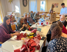 Gruppe gestaltet Adventkalender mit bunten Papiersäckchen und Bastelmaterial