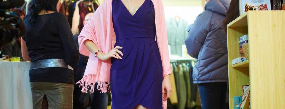 Eine Frau führt einem Publikum die Mode des carla Shops vor.