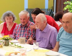 Bewohnerinnen, Bewohner und Gäste genießen gemeinsam das Jubiläumsfest zum 20-jährigen Bestehen des Pflegewohnhauses im festlich geschmückten Garten.