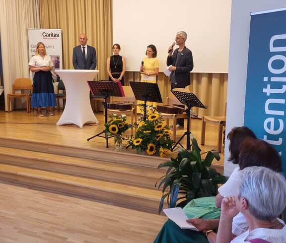 Fünf Menschen stehen auf einer Bühne.