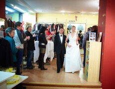 Ein Mann und eine Frau führen einem Publikum die Mode des carla Shops vor.