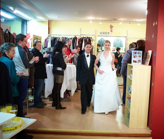 Ein Mann und eine Frau führen einem Publikum die Mode des carla Shops vor.