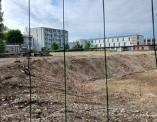 Blick durch ein Baustellengitter auf deine Bebauungsfläche