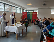 Bischof und Priester feiern die Messe im Saal des Haus Martha mit musikalischer Begleitung.
