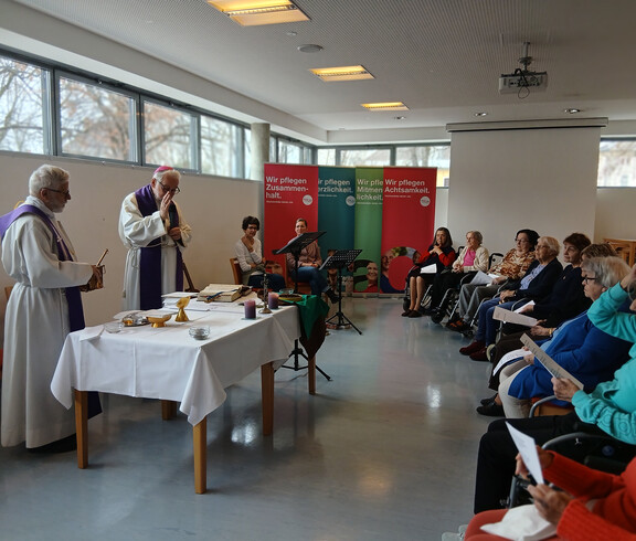 Bischof und Priester feiern die Messe im Saal des Haus Martha mit musikalischer Begleitung.