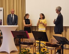 Vier Leute stehen am Podium und diskutieren.