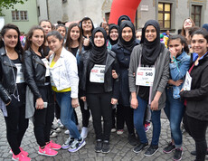 Ca. 15 Jugendliche und junge Erwachsene stehen in der feldkircher Innenstadt zu einem Gruppenfoto zusammen. Sie sind überwiegend dunkel gekleidet und manche junge Frauen tragen eine schwarze Kopfbedeckung. 