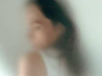 Unscharfes Portrait einer Person hinter einer halbtransparenten Oberfläche.